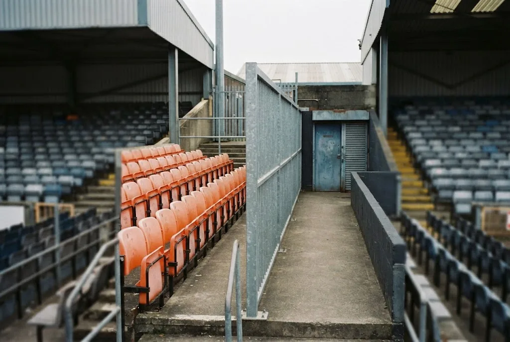 An empty away section of a stadium behind a segregation barrier